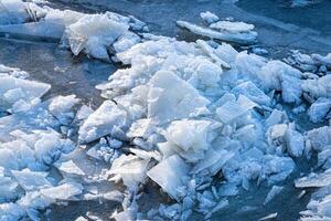 Melting ice floating on the river on a spring day. Cracked ice texture. photo