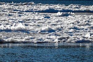 Melting ice floating on the river on a spring day. Cracked ice texture. photo