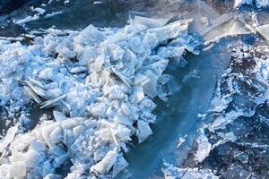 Melting ice floating on the river on a spring day. Cracked ice texture. photo