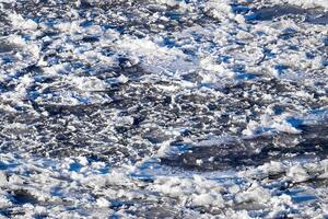 Melting ice floating on the river on a spring day. Cracked ice texture. photo