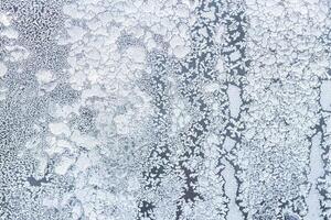 The texture of the glass covered with frost in winter in cold weather. Abstract background. photo