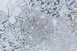 The texture of the glass covered with frost in winter in cold weather. Abstract background. photo