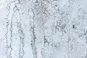 The texture of the glass covered with frost in winter in cold weather. Abstract background. photo