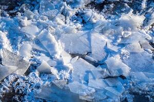 Melting ice floating on the river on a spring day. Cracked ice texture. photo