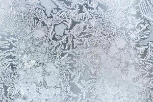 The texture of the glass covered with frost in winter in cold weather. Abstract background. photo