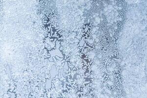 The texture of the glass covered with frost in winter in cold weather. Abstract background. photo