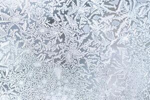 The texture of the glass covered with frost in winter in cold weather. Abstract background. photo