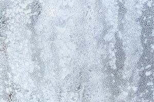 The texture of the glass covered with frost in winter in cold weather. Abstract background. photo