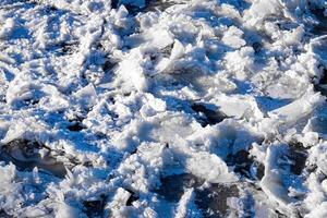 Melting ice floating on the river on a spring day. Cracked ice texture. photo