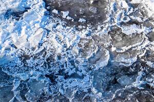Melting ice floating on the river on a spring day. Cracked ice texture. photo