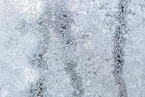 The texture of the glass covered with frost in winter in cold weather. Abstract background. photo