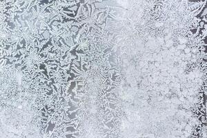 The texture of the glass covered with frost in winter in cold weather. Abstract background. photo