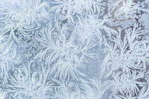 The texture of the glass covered with frost in winter in cold weather. Abstract background. photo