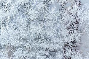 The texture of the glass covered with frost in winter in cold weather. Abstract background. photo