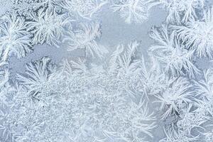 The texture of the glass covered with frost in winter in cold weather. Abstract background. photo