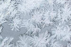 The texture of the glass covered with frost in winter in cold weather. Abstract background. photo
