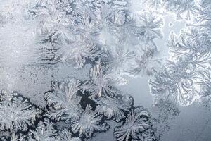 The texture of the glass covered with frost in winter in cold weather. Abstract background. photo