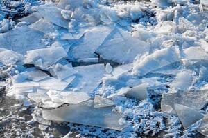 Melting ice floating on the river on a spring day. Cracked ice texture. photo