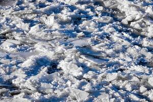 Melting ice floating on the river on a spring day. Cracked ice texture. photo