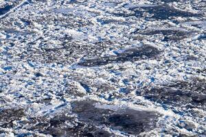 Melting ice floating on the river on a spring day. Cracked ice texture. photo