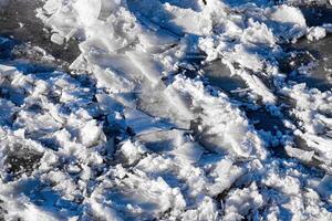 Melting ice floating on the river on a spring day. Cracked ice texture. photo