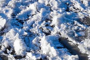 Melting ice floating on the river on a spring day. Cracked ice texture. photo
