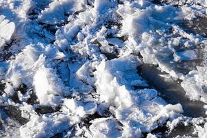 Melting ice floating on the river on a spring day. Cracked ice texture. photo