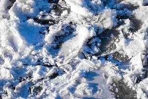 Melting ice floating on the river on a spring day. Cracked ice texture. photo