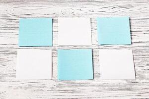 White and blue paper sheets on a wooden table. Abstract background for design. photo