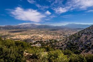 Top view of the Lassithi Plateau on a sunny clear day with a cloudy sky in the background. Crete island. photo