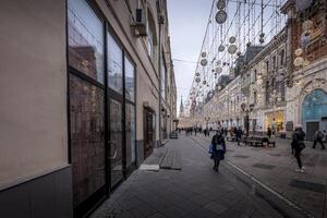 Tourists walking near illuminated facade of GUM Department store on the Red Square. photo