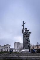 Tourists walking near Vladimir the Baptist statue on a cloudy overcast winter day. photo