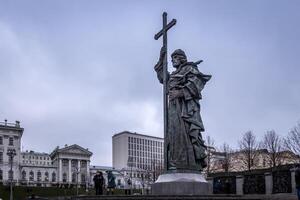 Tourists walking near Vladimir the Baptist statue on a cloudy overcast winter day. photo