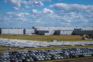 New cars parked in a distribution center on a sunny day in the summer. photo