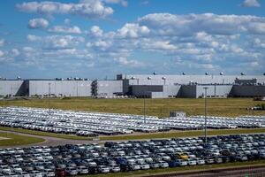 New cars parked in a distribution center on a sunny day in the summer. photo