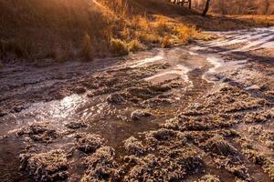 A melting or freezing stream in late autumn or early spring on a sunny day. photo