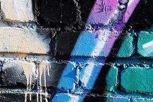 Fragment of colored graffiti painted on a brick wall. Abstract backdrop for design. photo