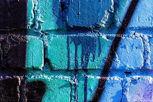 Fragment of colored graffiti painted on a brick wall. Abstract backdrop for design. photo