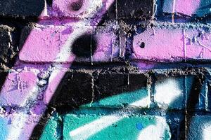 Fragment of colored graffiti painted on a brick wall. Abstract background for design. photo