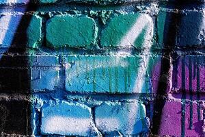 Fragment of colored graffiti painted on a brick wall. Abstract background for design. photo