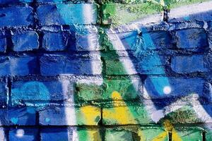 Fragment of colored graffiti painted on a brick wall. Abstract background for design. photo