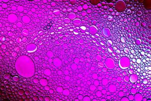Colorful drops of oil on the water. Purle colored circles and ovals. Abstract background for design. photo
