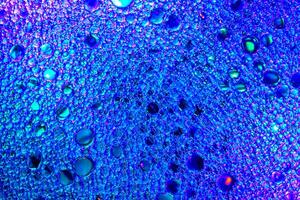 Colorful drops of oil on the water. Blue and purple colored circles and ovals. Abstract background for design. photo