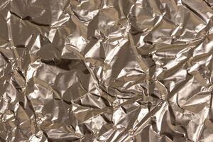Texture of crumpled golden foil. Abstract background for design. photo