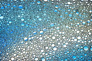 Top view on colorful drops of oil on the water. Blue circles and ovals. Abstract bright background for design. photo