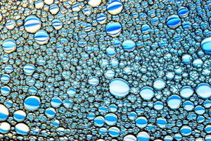Top view on a colorful drops of oil on the water. Rainbow or spectrum colored circles, ovals. photo