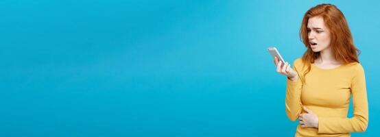 Lifestyle and Technology concept - Portrait of cheerful happy ginger red hair girl with joyful and exciting smiling to camera. Isolated on Blue Pastel Background. Copy space. photo