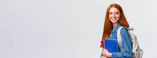 Girl seeing classmate in hall saying hi, turning back to greet someone, smiling joyfully, holding backpack and notebooks, heading back to class, studying in college, standing white background photo