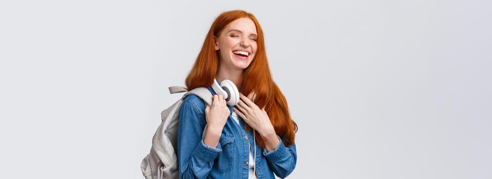 carismático y alegre, encantador simpático pelirrojo niña riendo terminado Novia broma como Bóveda espalda instalaciones desde Universidad clases, teniendo divertido risita con cerrado ojos, sonriente, participación mochila foto