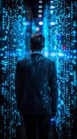 A man dressed in elegant attire stands in front of a vibrant blue light wall photo